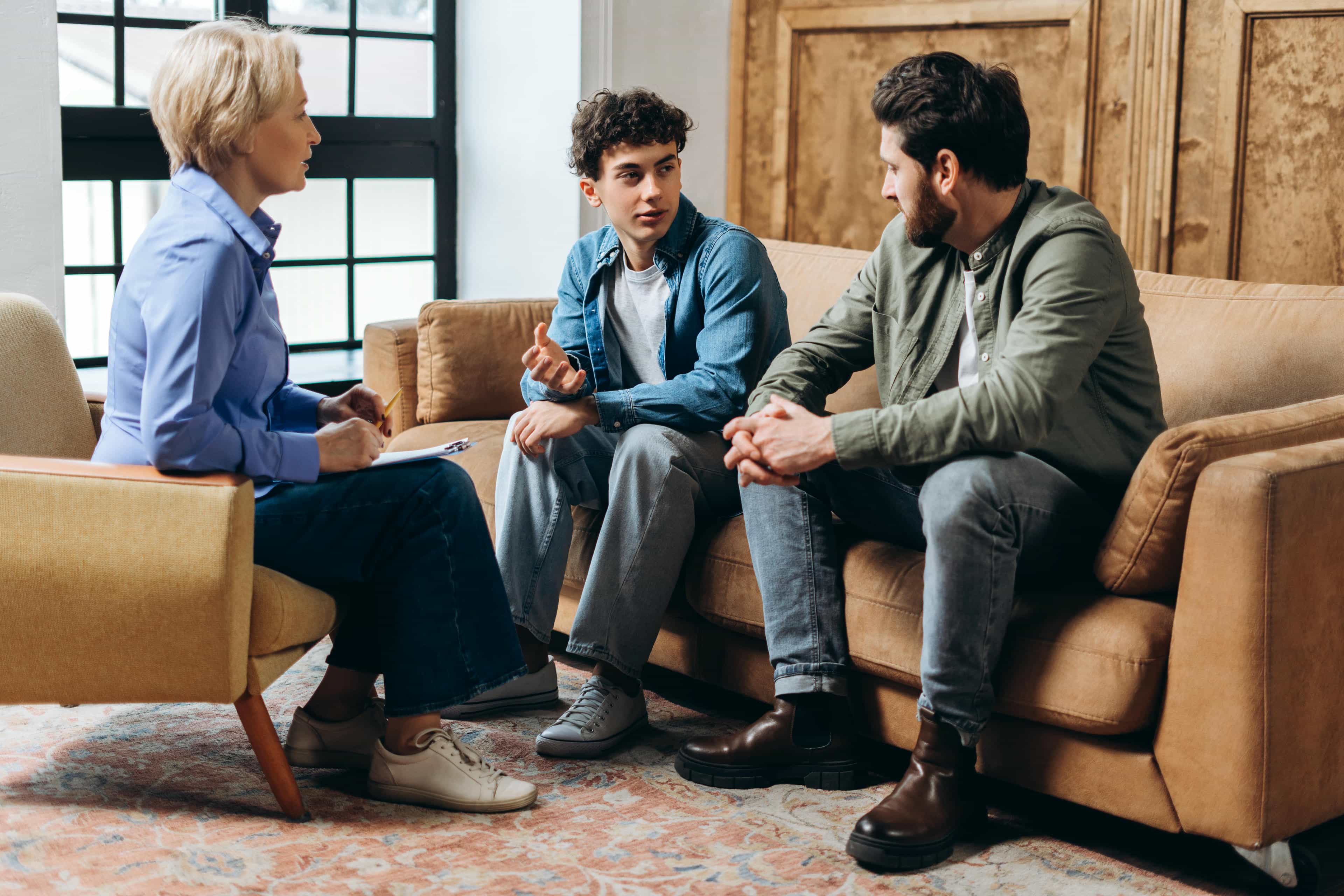 Three people having a serious conversation indoors.